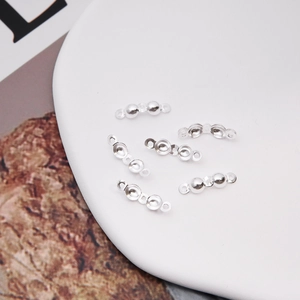 Macro shot of silver metal clamshell crimp bead connectors for DIY jewelry making