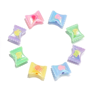 Close-up of candy-shaped acrylic beads with iridescent finish and rabbit motif