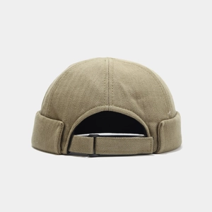 Close-up of herringbone fabric texture and adjustable metal buckle on solid color docker hat