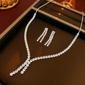 Detailed view of silver zircon tassel necklace and earrings set on a jewelry display