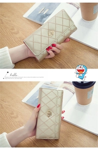 Macro detail of champagne gold quilted wallet with crown buckle and sleek finish