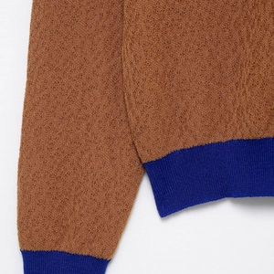 Braune strukturierte Strickjacke mit kontrastierenden dunkelblauen Rippbündchen am Saum