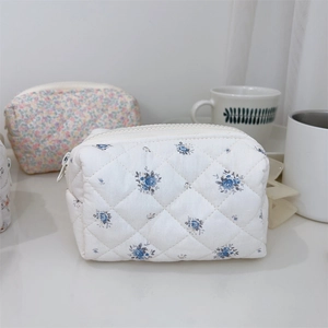 Détail de la trousse de maquillage en coton matelassé aux motifs floraux doux