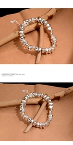 Detailed macro view of irregular silver beads and clasp on a minimalist metal bracelet
