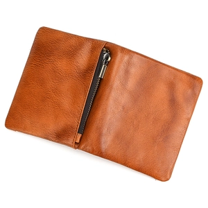 Detail view of the brown leather wallet interior showing a zipper pocket and grain texture