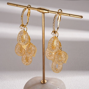 Elegant gold leaf tassel earrings with zircon accents displayed on a metal jewelry stand
