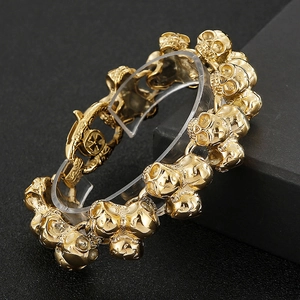 Macro detail of golden skull link bracelet in stainless steel with polished metallic finish