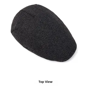 Detail of dark grey wool newsboy cap showing thick textured fabric and warm lining
