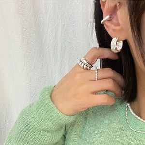 Close-up of minimalist 925 sterling silver knotted ring and earrings set on model