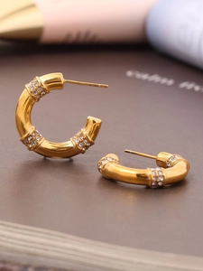 Detailed view of C-shaped gold-plated stainless steel earrings with sparkling zircons