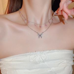 Detail of silver double-layer necklace with pink crystal drop and crystal butterfly pendant