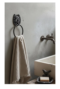 Rustic cast iron horseshoe towel ring with embossed horse head on industrial wall