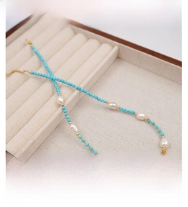 Detailed shot of turquoise beads and freshwater pearls on a velvet jewelry box