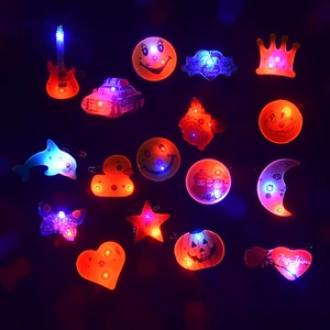Macro view of assorted LED light-up badges in star, heart, and guitar shapes