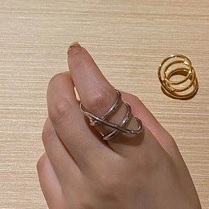 Close-up of gold and silver multi-layer crisscross rings with minimalist aesthetic