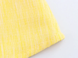 Close-up of yellow cotton linen fabric texture showing detailed woven fiber quality