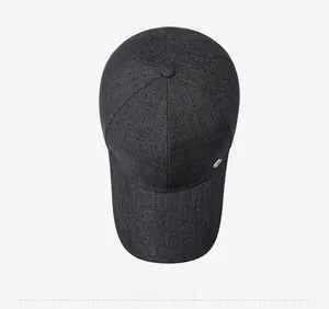 Top down view of dark grey baseball cap with twill texture and small silver metal logo