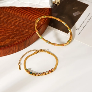 Detail of bamboo-style enamel bangle and colorful gemstone gold chain bracelet set