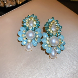 Detail of vintage flower earrings with blue crystals and large white pearls