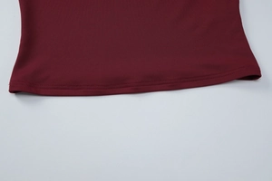 Détail de la couture à double aiguille sur l'ourlet en tricot bordeaux texturé