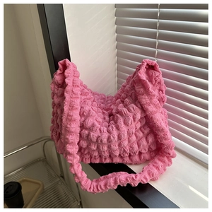 Close-up of pink bubble pleated fabric texture on a large capacity stylish shoulder bag