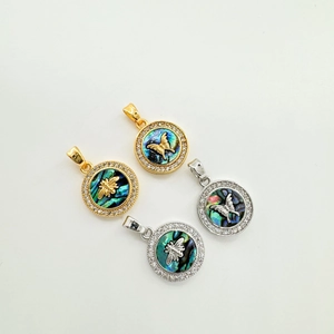 Detailed view of round shell pendants with zircon border and metal insect motifs