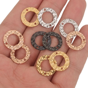 Handheld view of multi-color hammered stainless steel round pendants with double holes