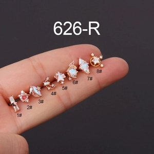 Set of 8 rose gold cartilage studs with aurora stones and stars shown on fingers