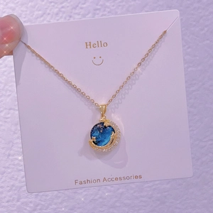 Dettaglio macro della collana luna dorata con pendente in gemma stellata blu e zirconi