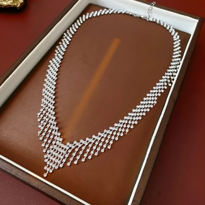 Detailed view of shimmering silver V-shaped tassel necklace with clear crystal accents