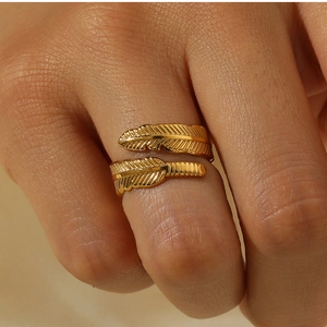 Detailed macro shot of an adjustable 18k gold plated feather ring on a model hand