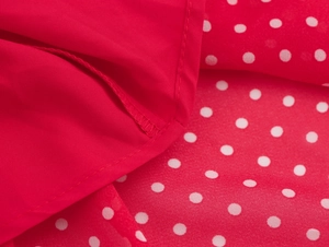 Vista macro dettagliata del tessuto rosso a pois bianchi e cucitura dell'orlo