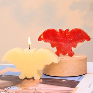 Halloween bat-shaped candle and glitter resin bat on round wooden base decor