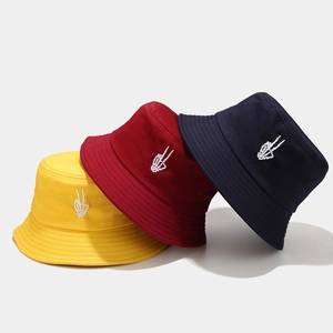 Three bucket hats in yellow, burgundy, and navy with skeleton hand embroidery