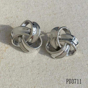 Detailed close-up of triple-loop interlaced knot earrings in polished silver stainless steel