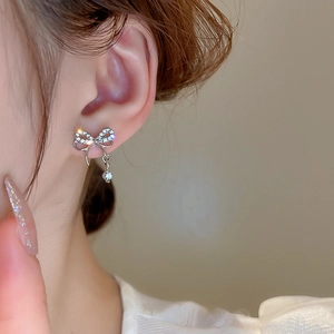 Boucles d'oreilles nœud double en argent avec cristaux portées par un mannequin