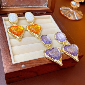 Vintage heart earrings in amber and purple tones displayed in a wooden jewelry box