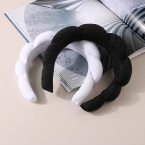 Close-up of black and white wavy spa headbands made of soft terry cloth material