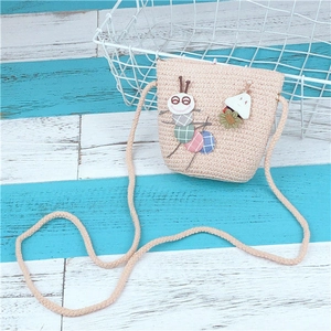 Detailed close-up of a pink woven straw crossbody bag with cute 3D cartoon caterpillar design