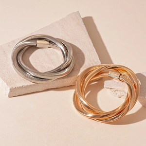 Modern twisted multi-layer metal bangle bracelets in polished gold and silver finishes