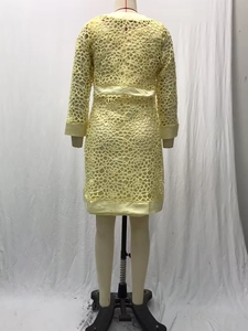 Vue arrière d'une robe midi en dentelle jaune à manches longues avec motifs ajourés sur mannequin