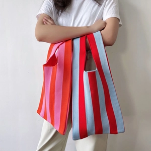Striped knit tote bags in orange-pink and red-blue styles carried by model