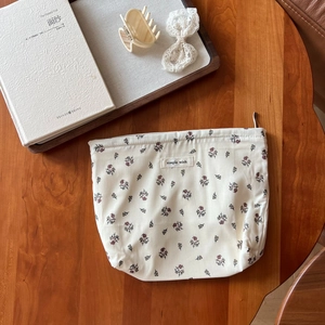 Floral cotton makeup bag with drawstring on wooden desk with books and accessories