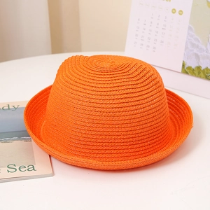 Détail d'un chapeau de paille orange vif pour enfant avec calotte ronde et bord roulé