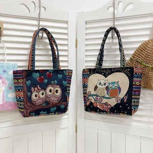 Detail of bohemian tote bags with owl embroidery and ethnic striped handles in soft light