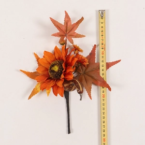 Detail view of artificial maple leaf and sunflower pick with ruler for size reference