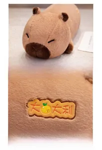 Close-up of the delicate orange embroidery on the soft brown capybara plush toy