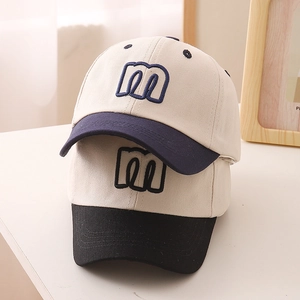 Detailed embroidery of letter M on a cotton kids baseball cap with contrast brim