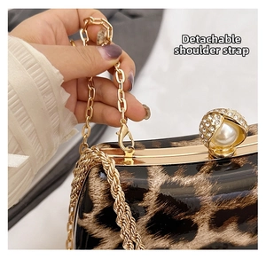 Detail of the detachable golden chain strap on a vintage leopard print box clutch bag