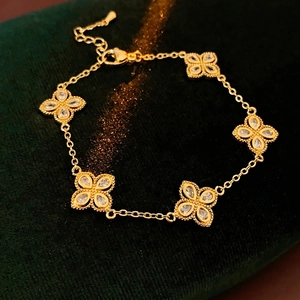 Luxurious gold clover bracelet with hollow floral charms and sparkling zircon inlays